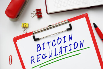  BITCOIN REGULATION inscription on the piece of paper.