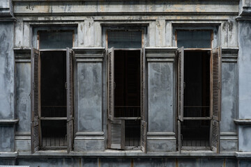 Fototapeta na wymiar Open wooden shutters on windows in the old building