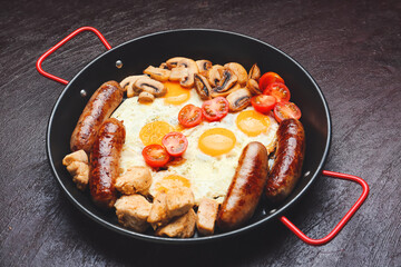 Frying pan with tasty breakfast on dark background