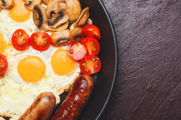 Frying pan with tasty breakfast on dark background