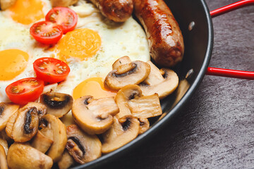 Frying pan with tasty breakfast on dark background, closeup