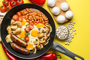 Frying pan with tasty breakfast on color background