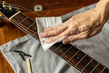 Cleaning guitar fretboard with wet wipes made for guitar