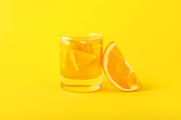 Glass of tasty orange jelly on color background