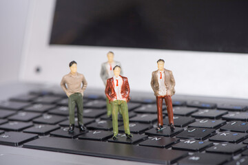 miniature businessman stand on laptop
