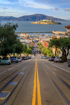 The iconic cable car tracks at the top of Hyde Street, with the famous Alcatraz Island in background in San Francisco, California, USA