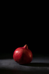 A red single pomegranate on black background. Fresh fruits.