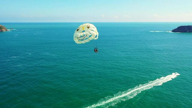 Aerial drone cinematic Couple Parasailing parachute over blue ocean Costa Rica Manuel Antonio
