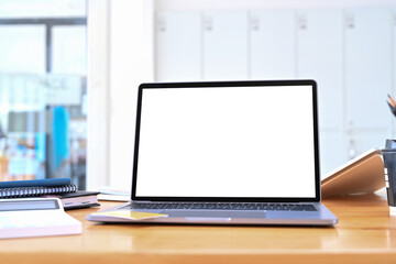 Close up view laptop with blank screen and calculator on wooden table.