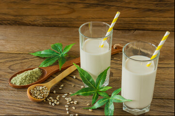 Glasses with Cannabis herbal vegan gluten and lactose free milk and cannabis leaves on wooden table
