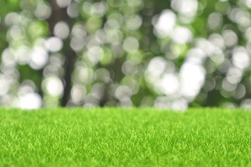 Fototapeta na wymiar Green artificial grass on natural daylight bokeh blur background