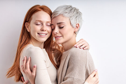 Two caucasian cool generation z women lgbtq lesbian couple dating in love hugging enjoying intimate tender sensual moment together feeling love isolated on white background. Close up photo