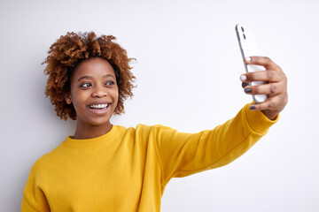 Happy African Woman Take Photo On Mobile Phone, Making Selfie On Mobile Phone, Portrait Of Curly Lady In Yellow Casual Shirt Posing, Smiling, Isolated On White Background