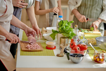 Close-up Photo of Cropped People Hands Holding Knife Cutting Food Meal For Cooking Using Cutting Board, Preparing Dinner, Family Time At Home, Cooking and Food Concept. Focus on Table