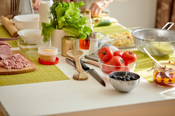 Close-up Photo of Cropped People Hands Holding Knife Cutting Food Meal For Cooking Using Cutting Board, Preparing Dinner, Family Time At Home, Cooking and Food Concept. Focus on Table