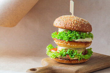 Vegan burger with vegetables and hummus, brown kraft background. Recycling food packaging, zero waste concept.