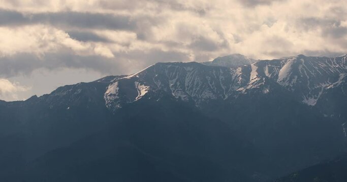 Timelapse with clouds over the Bucegi mountains in Romania during a spring day, as seen from the hills of Pestera village.