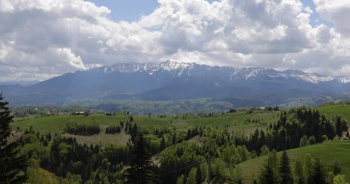 Heavy clouds over the Bucegi mountains in Romania during a spring day, as seen from the hills of Pestera village.