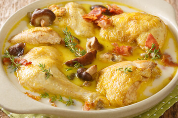 Stewed chicken in white wine with cream, bacon and mushrooms close-up in a saucepan on the table. horizontal © FomaA