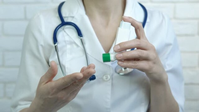 Speak about inhaler. A view of doctor hands with an inhaler. A concept of video in internet about healthcare.