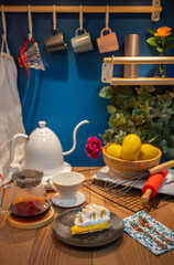 Lemon meringue pie, homemade style with coffee, placed on a wooden counter and espresso coffee cup hanging on the blue wall with warm lighting. Homemade style.