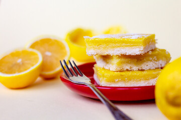 juicy yellow lemon cakes on a red plate, stack of citrus cookies with lemon filling lying one on top of another