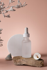 Cosmetic serum in glass bottle on stone podium. Natural cosmetic product packaging design, branding. beige background with white branch. vertical image
