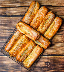 Many cheese and spinach rolls are arranged on a baking tray straight from the oven