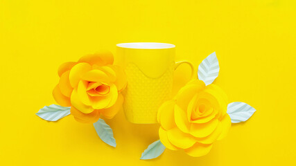 Yellow artificial flowers and yellow cup