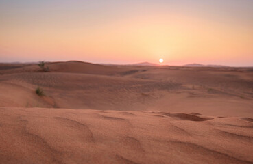 Sunset over the sand dunes in the desert.