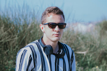 young man with headphones on the beach