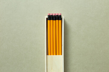 Yellow pencils in wooden pencil case on khaki background. top view, copy space - Powered by Adobe