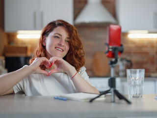 Technology and blogging concept. Redhair woman recording video concent for her blog at home