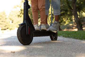 Obraz premium Mother and kid on electric scooter.