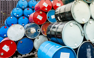 Old chemical barrels on wooden pallet. Blue and red oil drum. Steel and plastic oil tank. Toxic...
