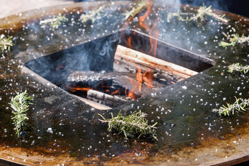 Fresh sprigs of rosemary around a barbecue fire