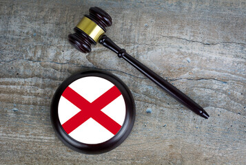 Wooden judgement or auction mallet with of Alabama flag. Conceptual image.