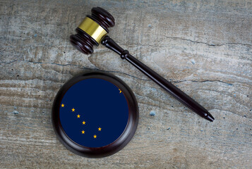 Wooden judgement or auction mallet with of Alaska flag. Conceptual image.