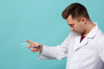 Doctor with gynecological mirror in hands isolated on blue background.