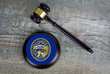 Wooden judgement or auction mallet with of Nebraska flag. Conceptual image.