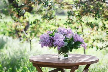 bouquet of lilacs on the table in the summer garden