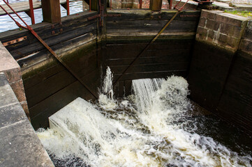 Old navigable river sluice. 20th century architecture with wooden mechanics. Augustow Canal,...