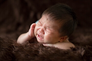 Cute Asian newborn baby on brown fur blanket background.
Nice portrait of little child boy.