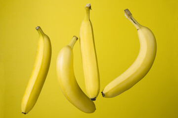 Bananas on a yellow background. Bright fruits. Four bananas on a colored background