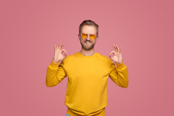 Cheerful man showing OK gesture and looking at camera