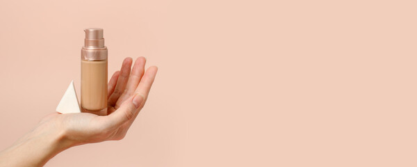 Applying foundation on makeup sponge. Woman's hands with neutral manicure holding bottle of concealer or toner foundation, cream and beauty blender, make up artist background, banner, flyer - 434269054