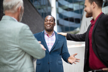 Businessman gesturing and talking to co-workers.