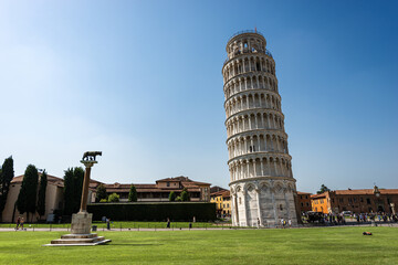 Leaning Tower of Pisa, bell tower of the Cathedral (Duomo di Santa Maria Assunta), Piazza dei Miracoli (Square of Miracles). Tuscany, Italy, Europe. On the left the monument of the she-wolf of Rome.