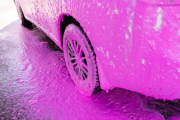 Cleaning, car wash, pink foam, background. Car wheels