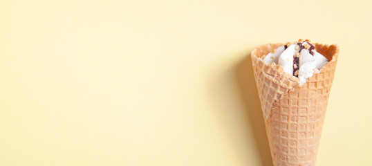  Ice cream in waffle cone on yellow background.